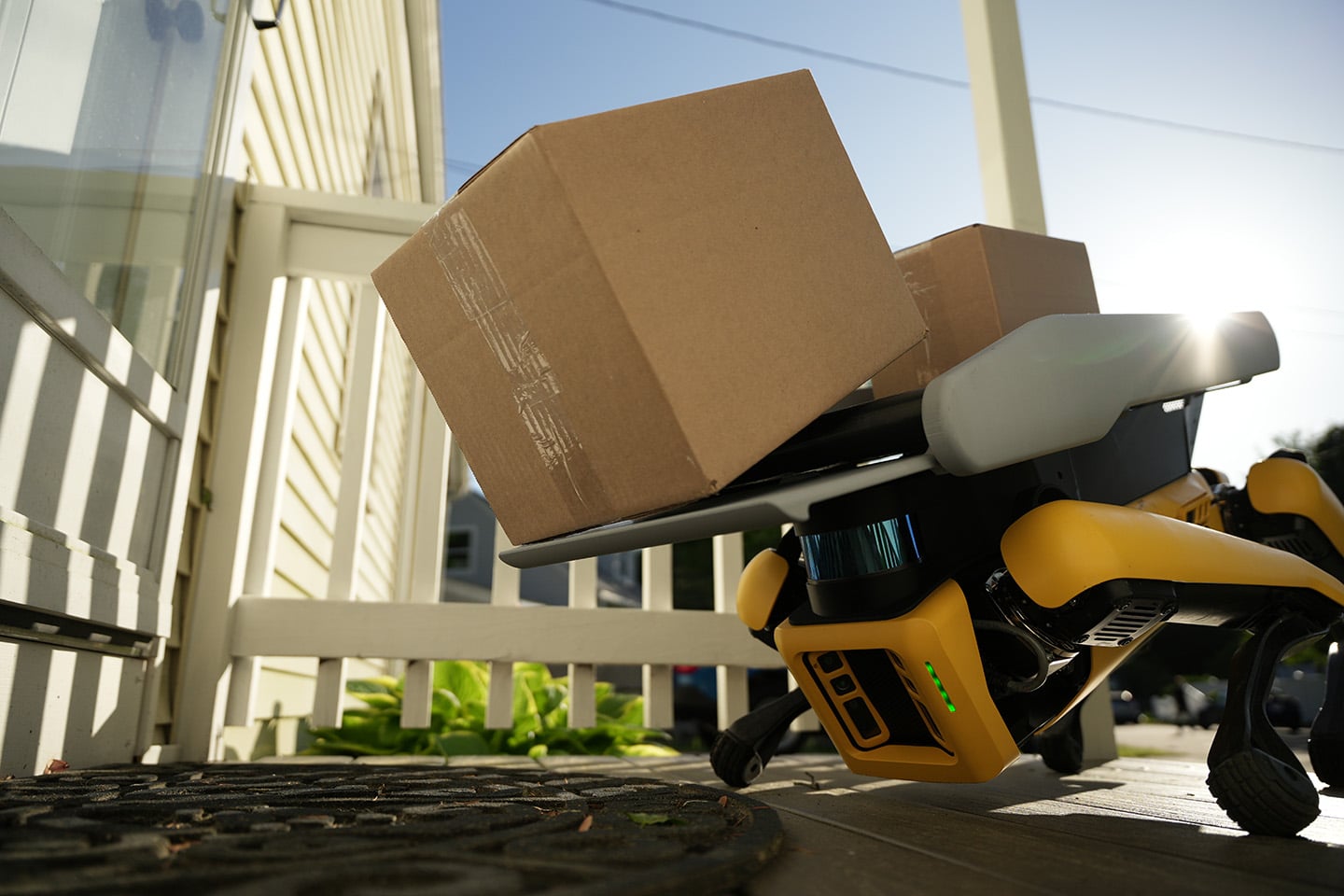 Boston Dynamics Spot robot unloading a package at a suburban porch